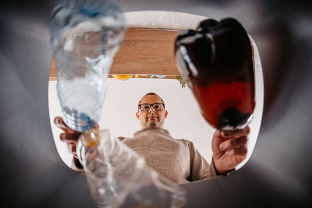 istock Young Man Putting Plastic Bottles In The Recycling Bin 1400087704