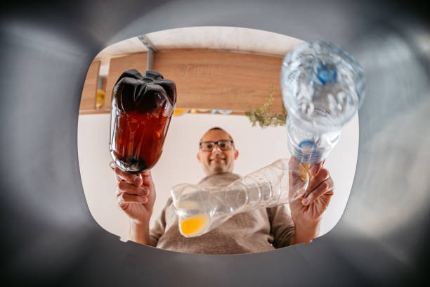 istock Young Man Putting Plastic Bottles In The Recycling Bin 1400087730