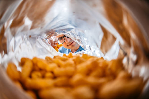 Young man's hand in a snack's bag from the camera's point of view.