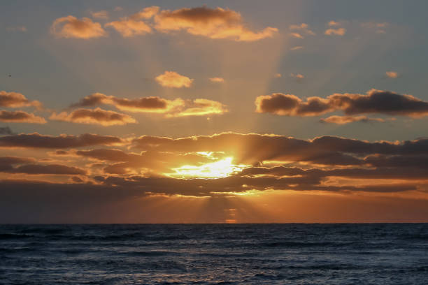 istock Seascape, sunset over the sea, the sun's rays break through the clouds 1400088555