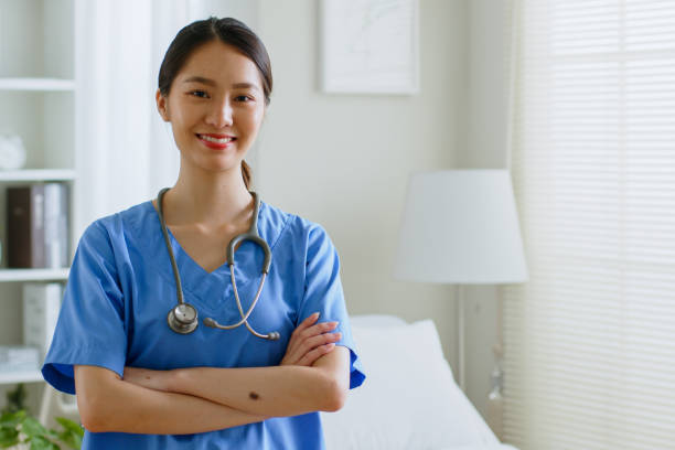 portret młodej azjatyckiej pielęgniarki uśmiechającej się w domu opieki lub szpitalu. spójrz na kamerę - doctor stethoscope nurse asian ethnicity zdjęcia i obrazy z banku zdjęć