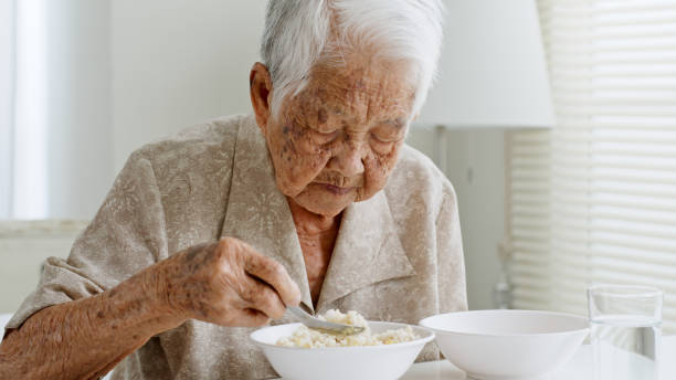 starsza azjatka siwe włosy jedzące jedzenie w domu opieki - sadness nursing home senior adult old zdjęcia i obrazy z banku zdjęć