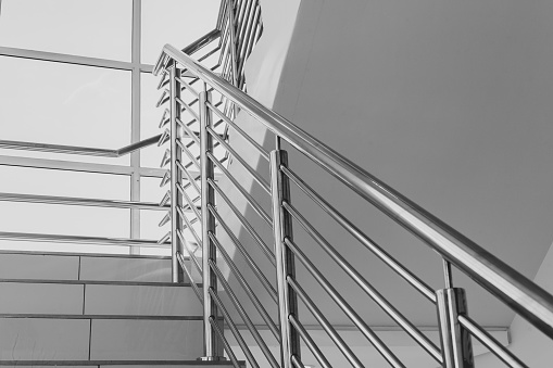 Building steps with stainless steel hand rail for public safety close-up decor interior design.