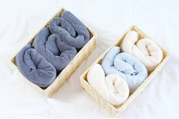 istock Folded towels in wicker boxes close-up top view on white background, space organization concept. 1400095141