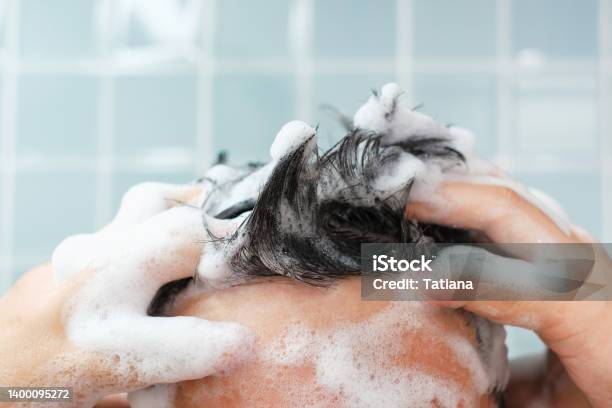 Male Hands Wash Their Hair With Shampoo And Foam On Blue Background Front View Stock Photo - Download Image Now
