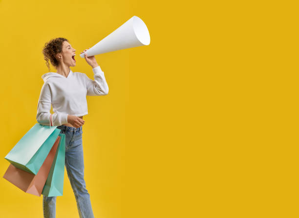 istock Girl holding packages, speaking in megaphone. 1400097319