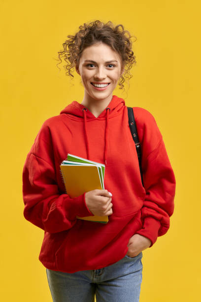 Pretty girl with curly hair standing, smiling. stock photo