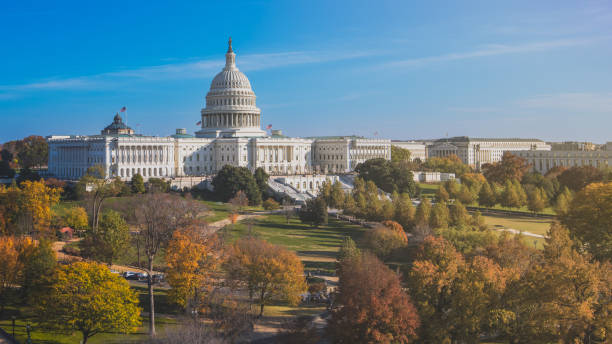 Front view of United States Capitol Hill in fall on clear sky day White marble domed building that serves as seat of American federal government legislative branches, House of Representatives and Senate with autumn trees in foreground us republican party photos stock pictures, royalty-free photos & images
