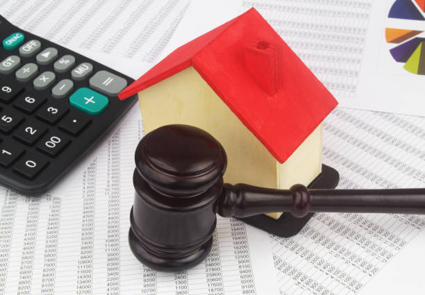 istock Judge gavel and house model with calculator on financial data. 1400101276
