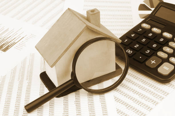 istock House model with magnifying glass and calculator on financial documents. 1400101280