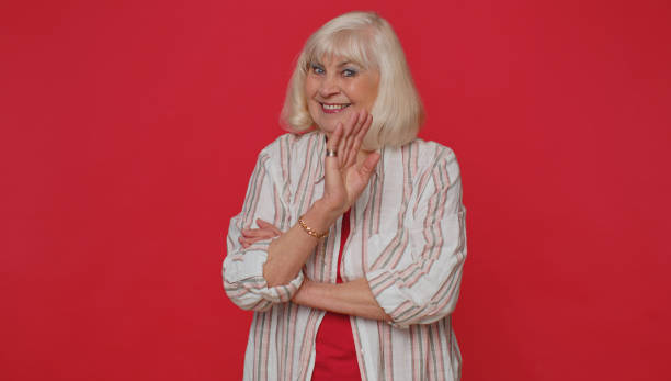 istock Senior woman smiling friendly at camera and waving hands gesturing hello or goodbye, welcoming 1400103610