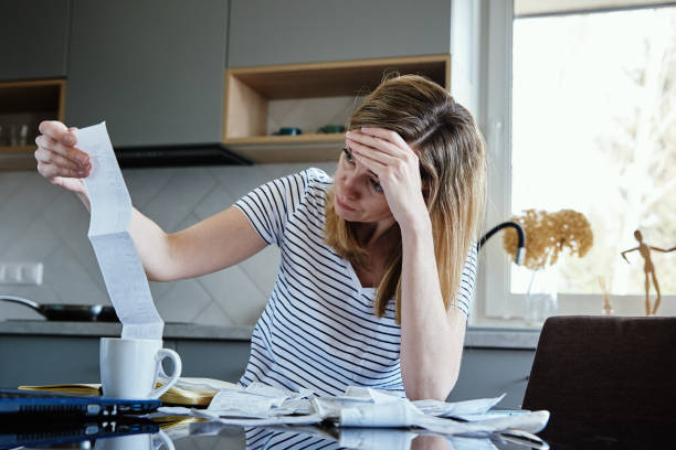 Woman calculating payment bill in kitchen Woman looking at paper bill and counting expenses, Planning budget and home finance management cost of living stock pictures, royalty-free photos & images