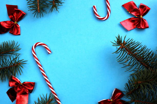 istock Christmas background made of bows and small spruce branches on a blue background with space for text. 1400103737