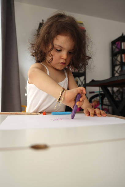 istock Little child girl draws with colored pencils. 1400103773