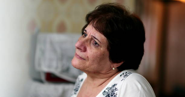 istock Sad pensive older woman looking out through window. Thoughtful depressed lady 1400104477