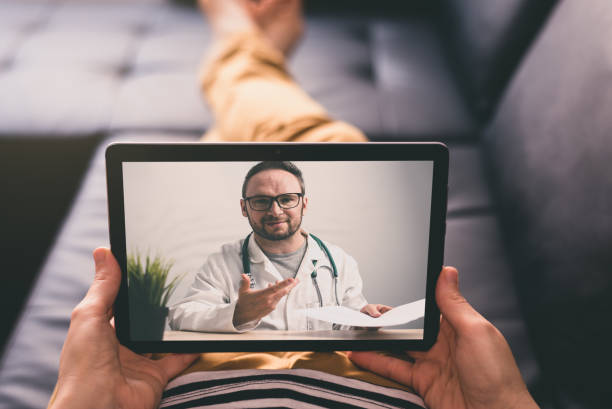 istock Woman lying on a sofa and talking with a doctor online using digital tablet. Telemedicine concept. 1400105073