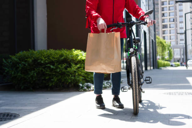 istock Delivery man with bicycle and paper bag 1400106043