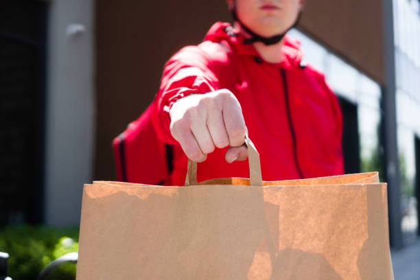 istock Delivery man holding paper bag 1400106083