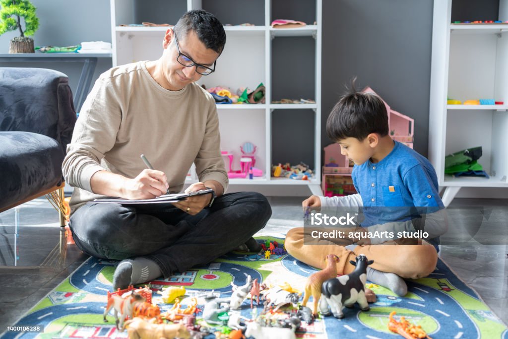 Child Psychotherapy A Professional Child Psychologist Observing Little Boy Playing With Toys At The Psychotherapy Session Child Stock Photo