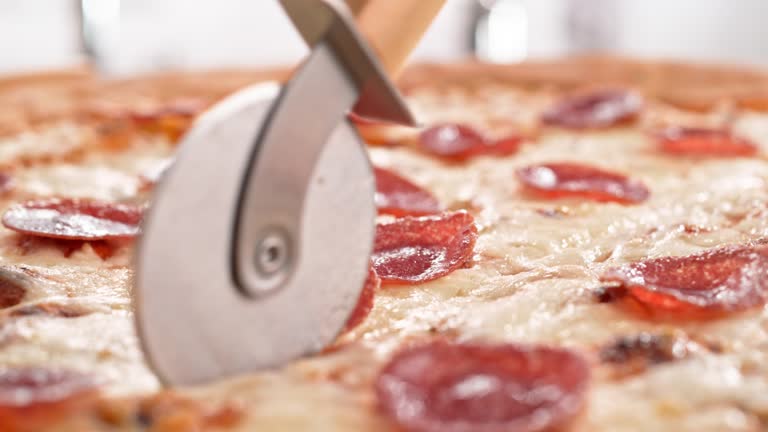 New York Style Pepperoni Pizza Sliced with Pizza Cutter in Slow Motion and Macro