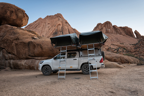 Spitzkoppe, Namibia - October 11, 2021: Two roof tents mounted on a Toyota HILUX off-road vehicle. This is a typical camping scene in Namibia, Africa: Sleeping outdoors in nowhere land at Spitzkoppe region.