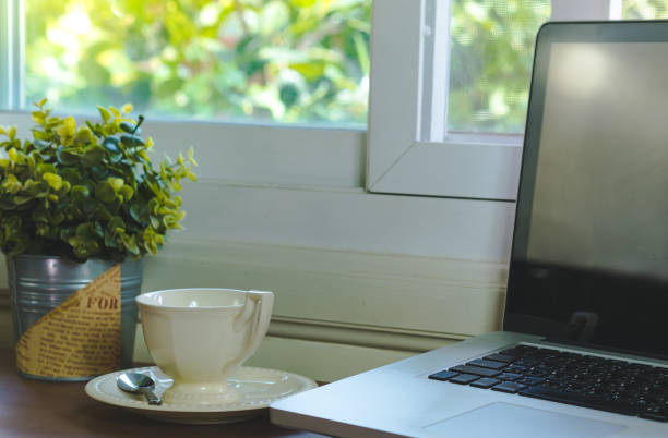 istock Computer and coffee cup on desk and plant pots.business nature concept. 1400109612