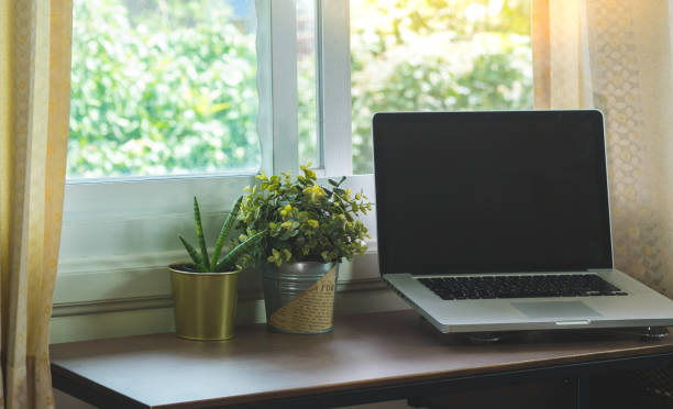 istock The window work area has a computer and potted plants against a natural green background.business nature concept 1400109634