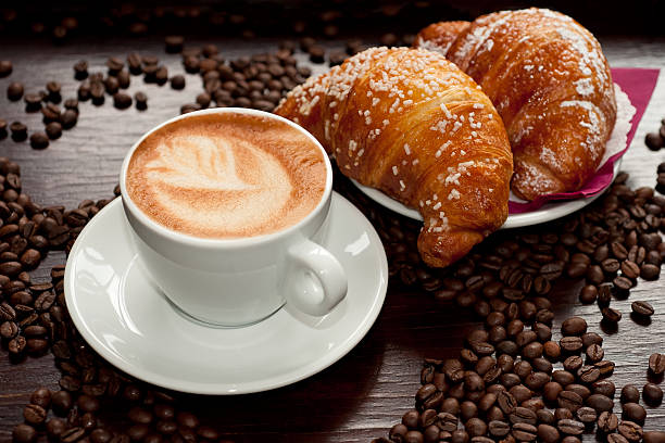 istock A cappuccino next to two croissants and roasted coffee beans 140011030
