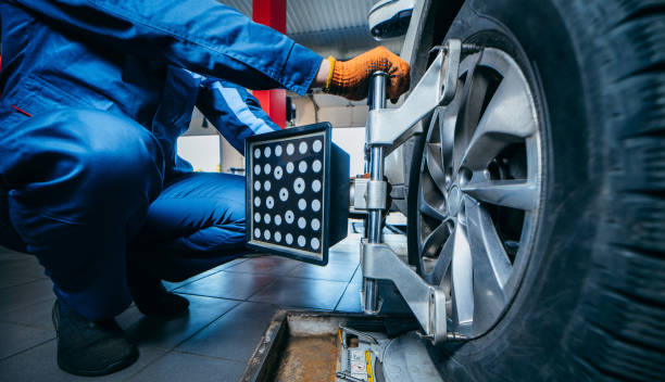 istock Auto mechanic installing sensor during suspension adjustment and automobile wheel alignment work at repair service station. Close up 1400111980