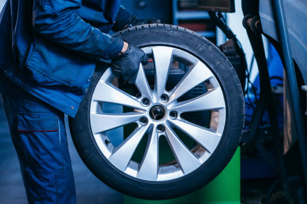istock Auto mechanic uses tire balancing machine and turning tire 1400112017