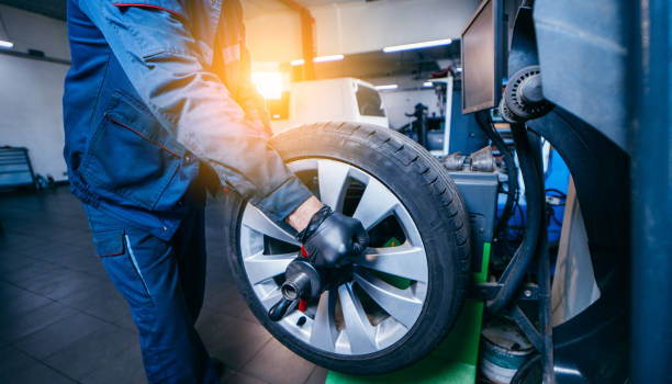 istock Auto mechanic uses tire balancing machine and turning tire 1400112027