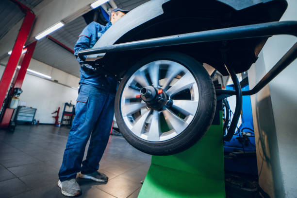 istock Auto mechanic uses tire balancing machine and turning tire 1400112058