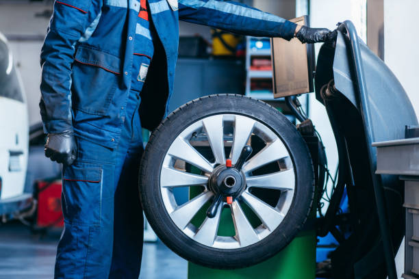 istock Auto mechanic uses tire balancing machine and turning tire 1400112061