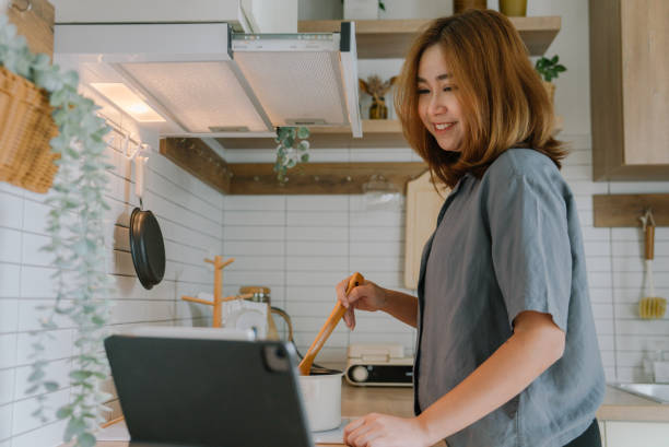 istock Happy asian woman using tablet in kitchen 1400112425