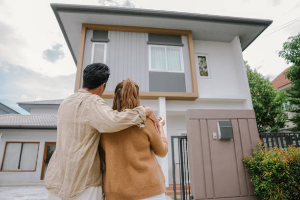 Rear view couple standing in front of new home. stock photo