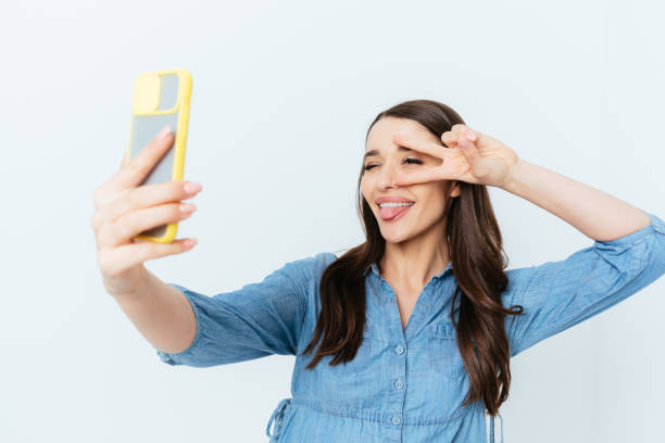 istock Cheerful young brunette woman taking selfie 1400114847