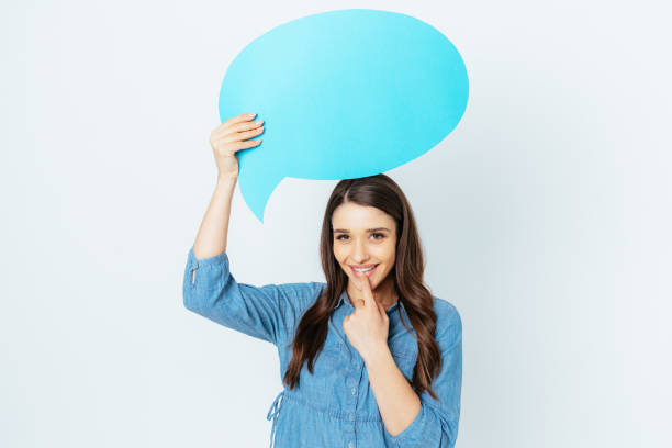 istock Cute happy young woman holding blank speech bubble 1400114859