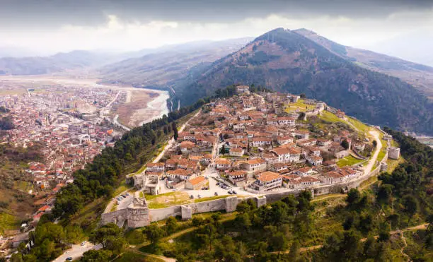 Aerial photo of Albanian city Berat with view of castle walls and tiled roofs of houses.