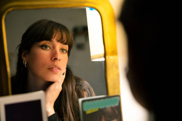 istock Beautiful young woman looking herself in the mirror 1400116346