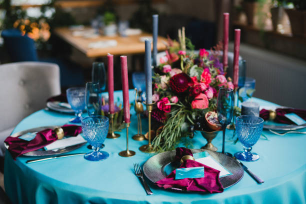 istock Table setting at the wedding reception. Floral compositions with beautiful flowers and greenery, candles, laying and plates on a decorated table. 1400116576
