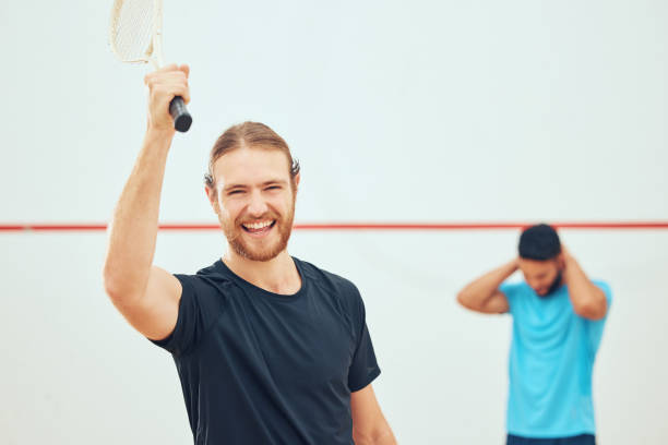istock Young athletic squash player winning after playing opponent in competitive court game. Fit active caucasian athlete celebrating success after training challenge in sports centre. Smiling sporty man 1400118193