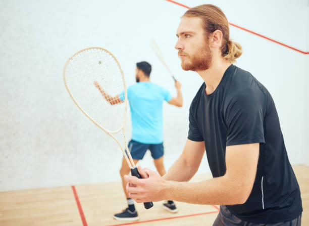 istock Young athletic squash player getting ready for playing opponent in competitive court game. Fit active caucasian athlete looking focused during training challenge in sports centre. Waiting for serve 1400118199