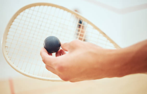istock Unknown athletic squash player getting ready for playing opponent in competitive court game. Fit active athlete holding racket and ball to serve during training challenge in sports centre. Sporty men 1400118220
