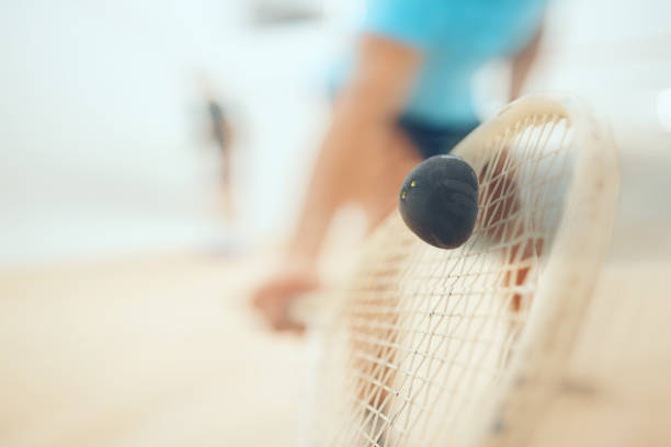 Closeup of unknown athletic squash player using a racket to hit a ball during a court game. Fit active mixed race male athlete training and playing in a sports centre. Healthy cardio and motion blur primer plano de un jugador de squash atlético desconocido que usa una raqueta para golpear una pelota durante un juego de cancha. apto atleta masculino de raza mixta activa entrenando y jugando en un centro deportivo. cardio saludable y desenfoque de movi