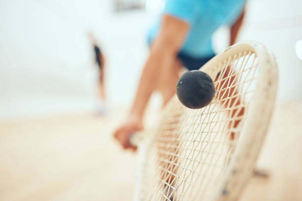 Closeup of unknown athletic squash player using a racket to hit a ball during a court game. Fit active mixed race male athlete training and playing in a sports centre. Healthy cardio and motion blur primer plano de un jugador de squash atlético desconocido que usa una raqueta para golpear una pelota durante un juego de cancha. apto atleta masculino de raza mixta activa entrenando y jugando en un centro deportivo. cardio saludable y desenfoque de movi