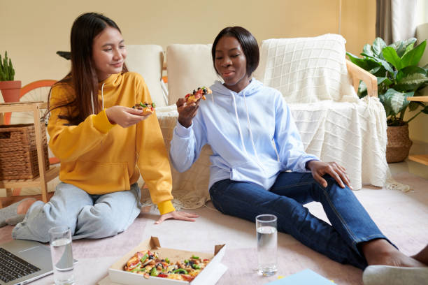 filles mangeant de délicieuses pizzas - black olive photos et images de collection