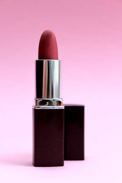 istock Burgundy lipstick stands on a lilac background. 1400121137