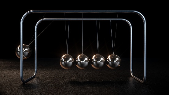Metallic Newton's Cradle Swinging On Black Background. Balance, Stability.