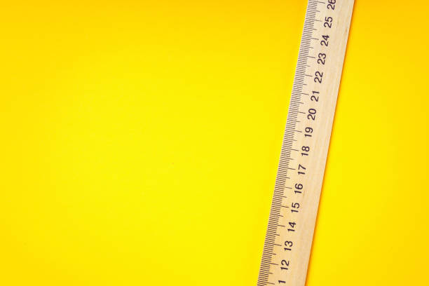 istock Wooden ruler on a yellow background with copy space. 1400127372