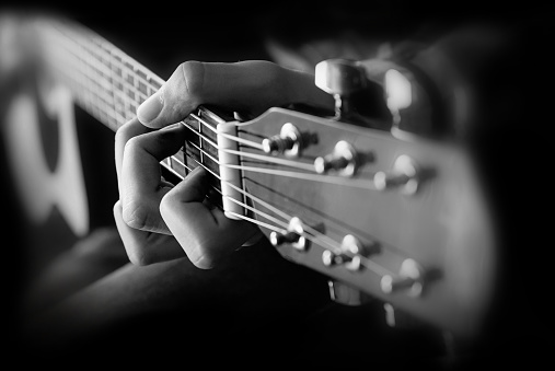 Close up of man hand playing guitar. Black and white closeup Photography.